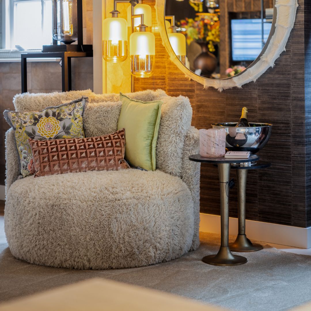 Textuur in het interieur 4 Een witte teddy fauteuil met verschillende gekleurde kussens